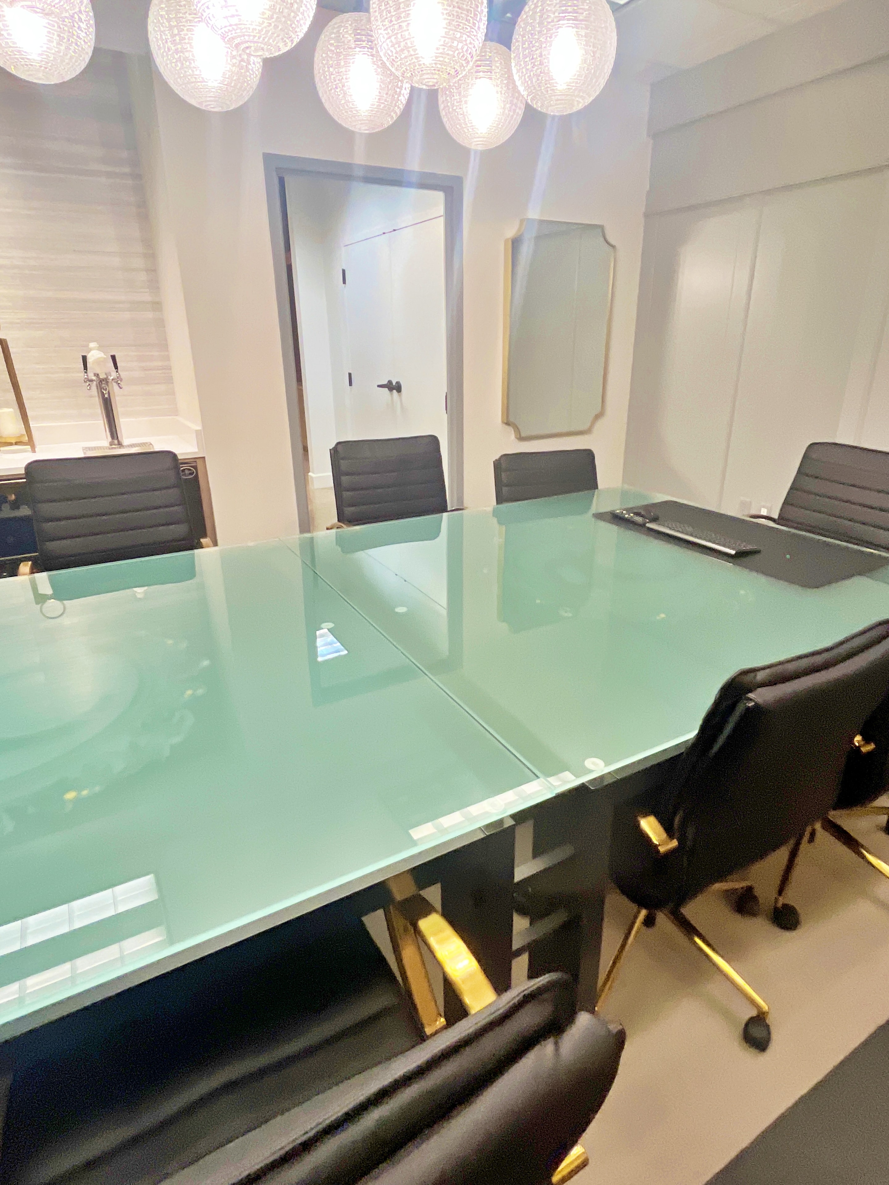 Clean conference room with glass table and modern lighting